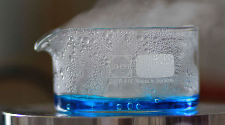 Kristallisierschale auf Heizplatte mit blauer verdampfender Flüssigkeit