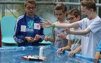 Vier Schüler testen ein selbst gebasteltes Boot