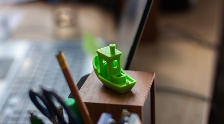 Ein 3D-Druck eines kleinen Schiffs steht auf einem Stiftehalter auf einem Schreibtisch