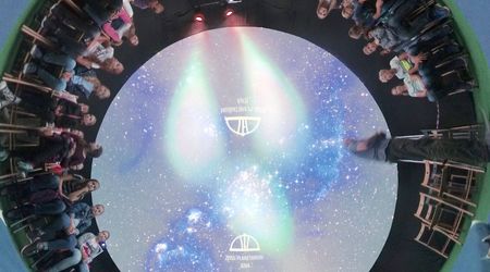 Schülerinnen und Schüler sitzen im mobilen Planetarium, ein 360°-Aufnahme zeigt eine Vorstellung im Planetarium